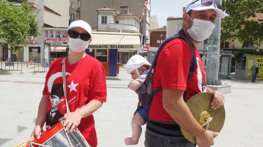 Öğretmen sırtında çocuğu ile halk bandosunda görev aldı