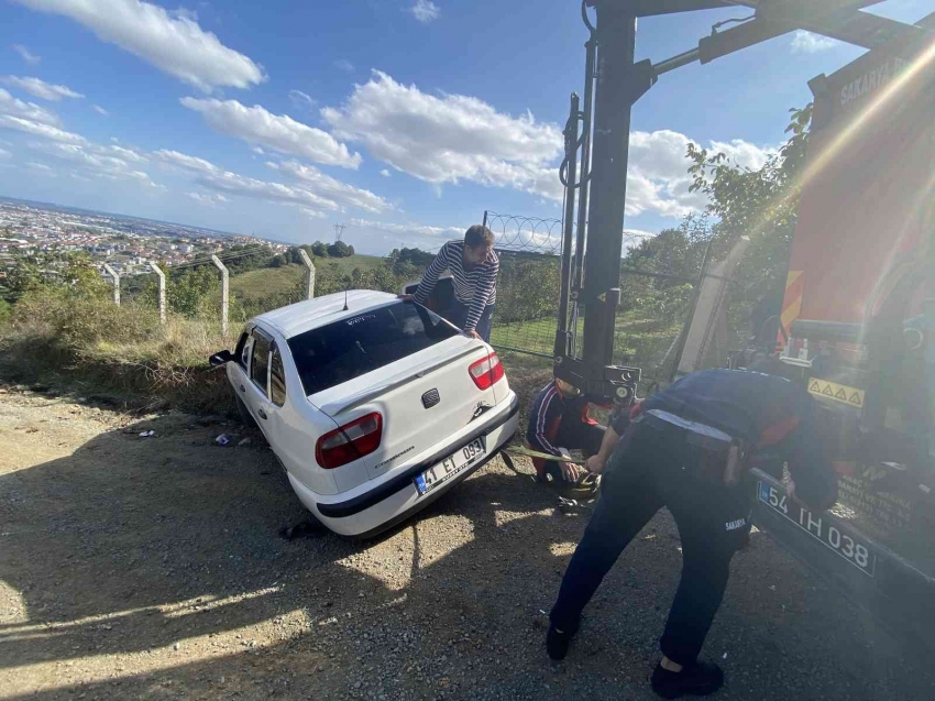 Devrilme riski olan otomobilini kurtarmak için üzerine çıktı