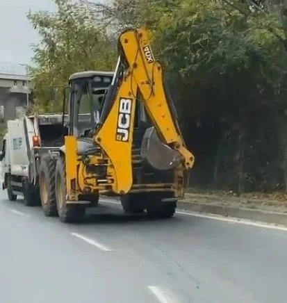 Arıza yapan çöp kamyonunu iş makinasıyla iterek götürdüler