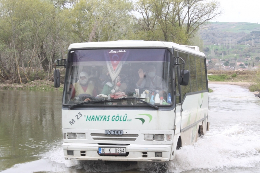 Su altında kalan köprüden tehlikeli geçiş