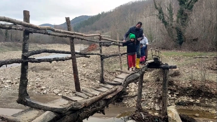 Evlerine ulaşmanın tek yolu derme çatma köprü
