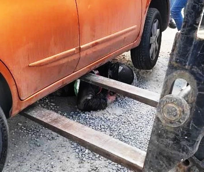 Mıcırda kayan motosiklet otomobilin altına girdi
