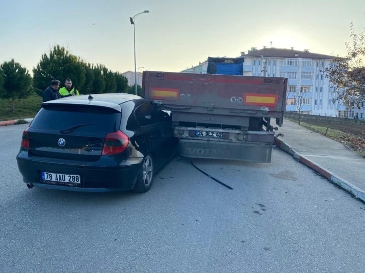 Otomobil park halindeki tırın altına girdi