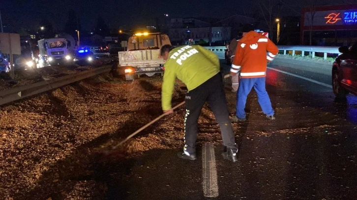 Polis eline aldığı fırçayla devrilen tırdan yola dökülen talaşı temizledi
