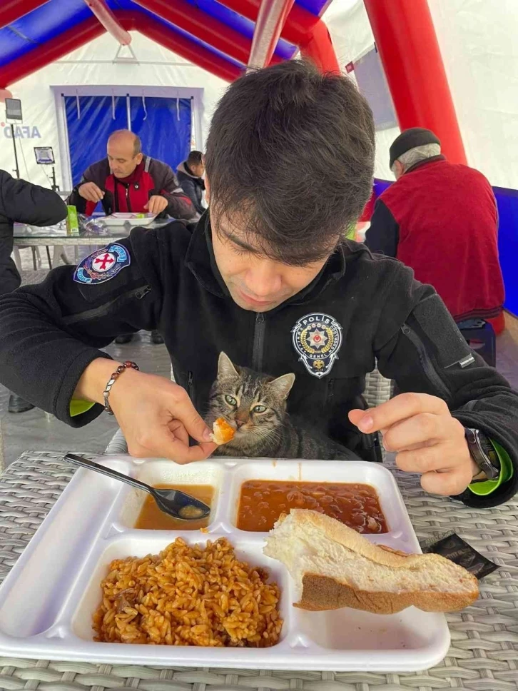 Polis yemeğini kucağına aldığı kedi ile paylaştı
