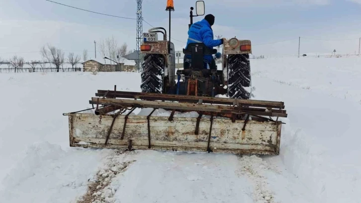 Traktörün arkasına bağladığı aparatla mahallenin yolunu açıyor
