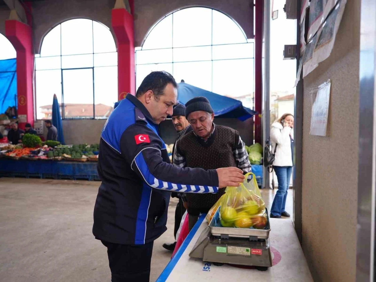 Vatandaş aldığı ürünün kilosunu kontrol ediyor
