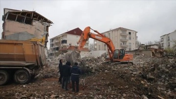 Depremde camları dahi kırılmadan yan yatan binanın enkazı kaldırılıyor