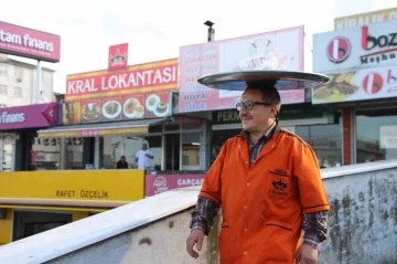 Sipariş verilen yemekleri kafasında taşıdığı tepsi ile götürüyor
